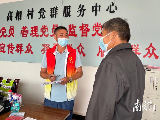 正在為群眾辦事的沈家江（左）。