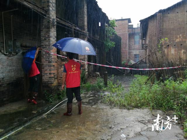 黨群志愿者冒雨拉起警戒線。