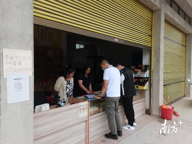 執(zhí)法人員給商家細致解釋政策。