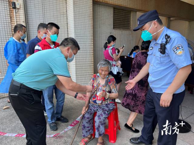 連州市委常委、副市長、九陂鎮(zhèn)黨委書記綦鴻偉在核酸檢測現(xiàn)場協(xié)助老人參加核酸檢測，為老人做好防暑措施。
